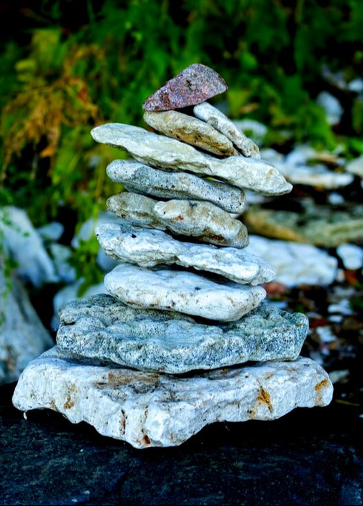 Several flat rocks are balanced on top of each other